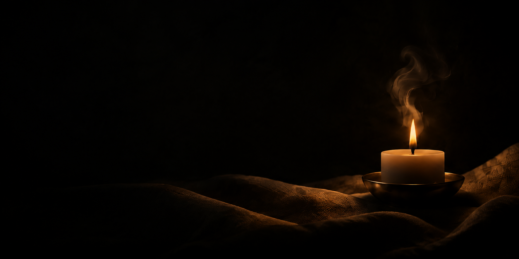 A single candle glowing softly in the dark